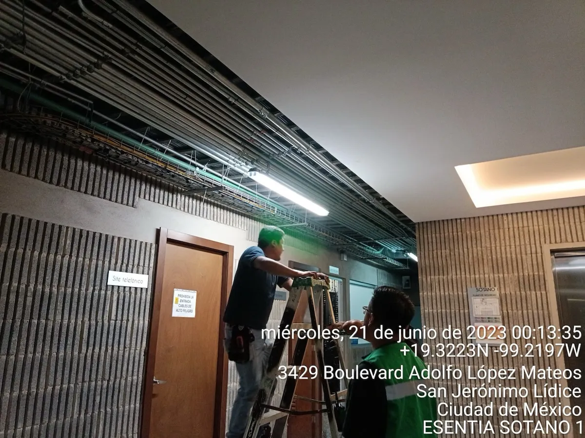 Técnico montando cámara de seguridad en soporte metálico y conduit