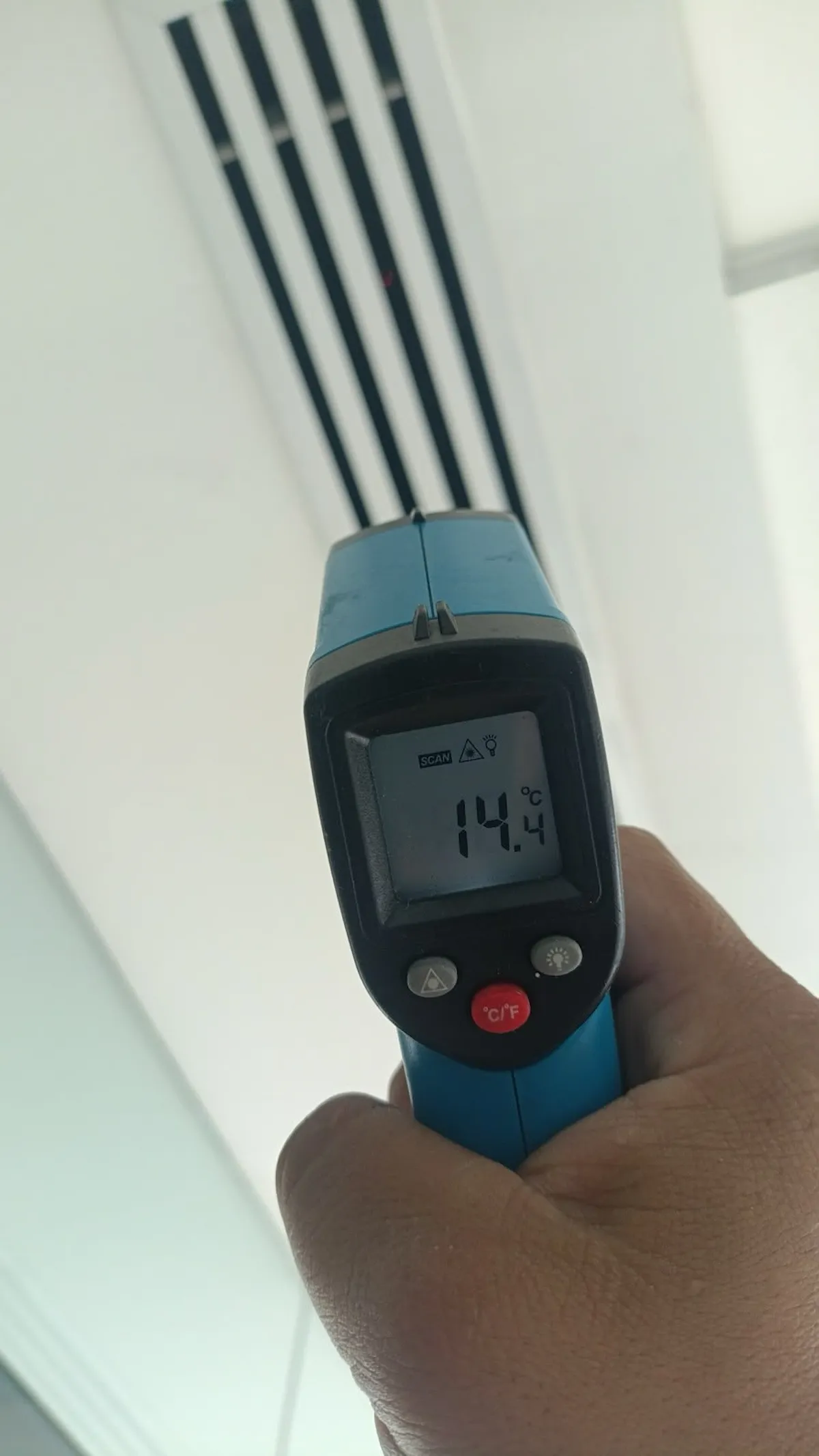 Medición de temperatura en rejilla de aire acondicionado con termómetro infrarrojo